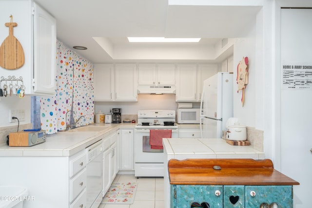 565 Jones Dr Unit 3B, Lake Havasu City, AZ 86406 - kitchen with white appliances, under cabinet range hood, a sink, white cabinetry, and light tile patterned floors