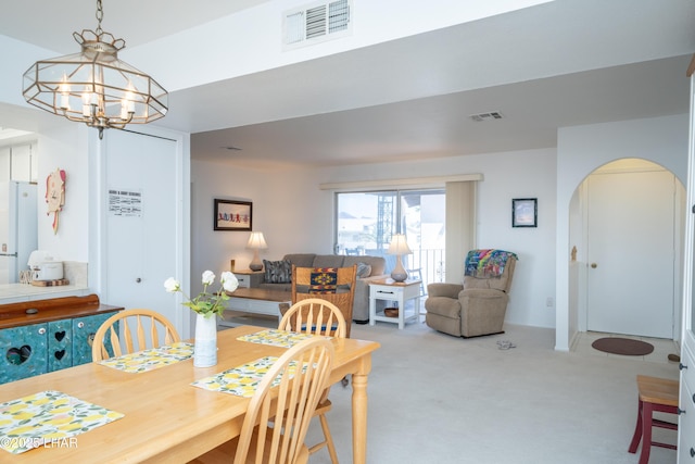 565 Jones Dr Unit 3B, Lake Havasu City, AZ 86406 - dining area featuring arched walkways, carpet, and a chandelier