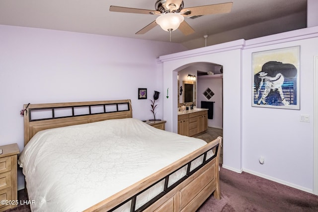 2641 Palo Verde Blvd N, Lake Havasu City, AZ 86404 - bedroom with arched walkways, baseboards, a ceiling fan, ensuite bath, and dark colored carpet