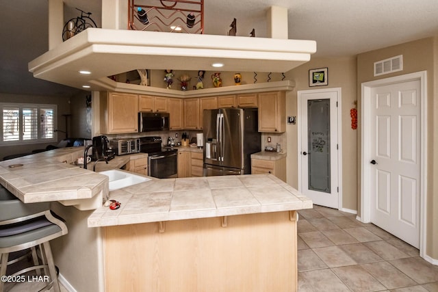 2641 Palo Verde Blvd N, Lake Havasu City, AZ 86404 - kitchen featuring tile countertops, visible vents, appliances with stainless steel finishes, a sink, and a peninsula