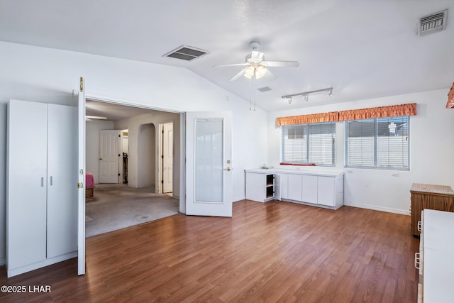 2974 Caravelle Dr, Lake Havasu City, AZ 86406 - unfurnished living room featuring ceiling fan, arched walkways, lofted ceiling, wood finished floors, and baseboards