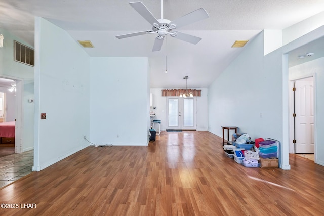 2974 Caravelle Dr, Lake Havasu City, AZ 86406 - unfurnished living room featuring a ceiling fan, lofted ceiling, wood finished floors, and a chandelier