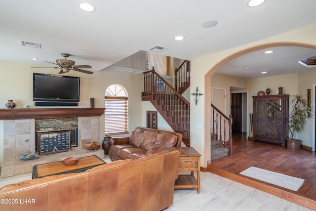 1351 London Bridge Rd Unit 2, Lake Havasu City, AZ 86404 - living room featuring ceiling fan, a fireplace, arched walkways, visible vents, and stairway