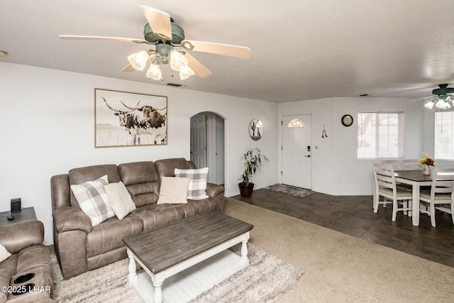 living room with visible vents, arched walkways, and ceiling fan