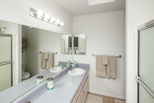 bathroom with a shower with door, visible vents, toilet, and vanity