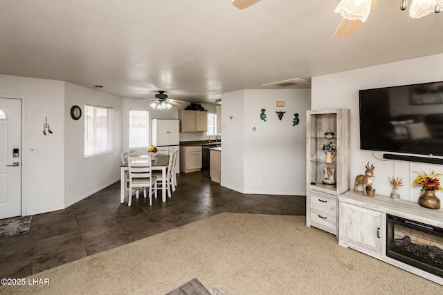 interior space with visible vents, dark carpet, baseboards, and a ceiling fan