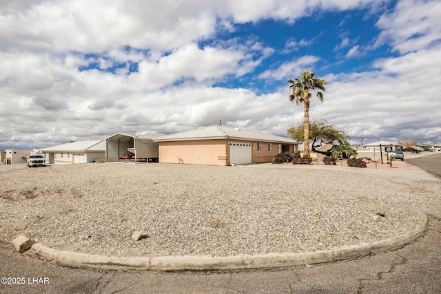 view of front facade with a carport, stucco siding, an attached garage, and concrete driveway