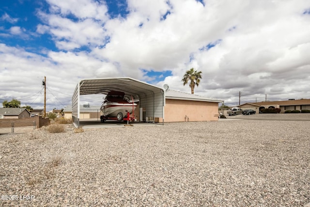 view of outdoor structure with a detached carport and fence