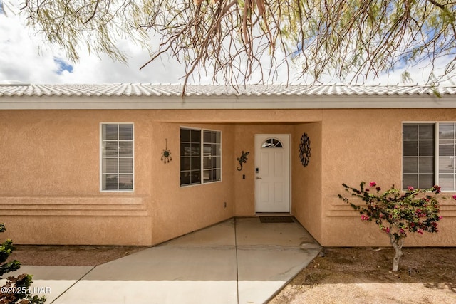 view of exterior entry featuring stucco siding