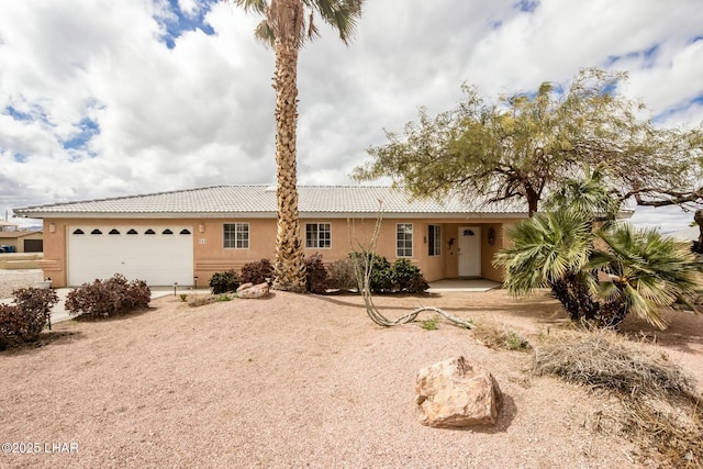 ranch-style house featuring stucco siding, a tile roof, and a garage