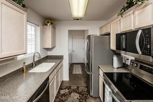 kitchen with a sink, visible vents, appliances with stainless steel finishes, and light brown cabinets