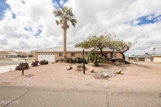 ranch-style home with stucco siding, a tiled roof, and an attached garage