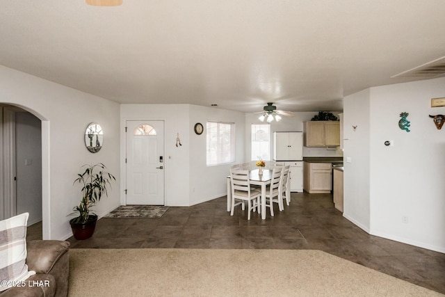 foyer featuring arched walkways, visible vents, baseboards, and a ceiling fan