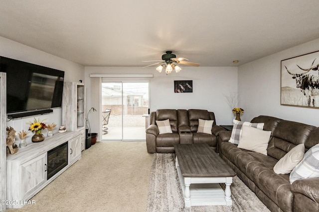 living area featuring light carpet and ceiling fan