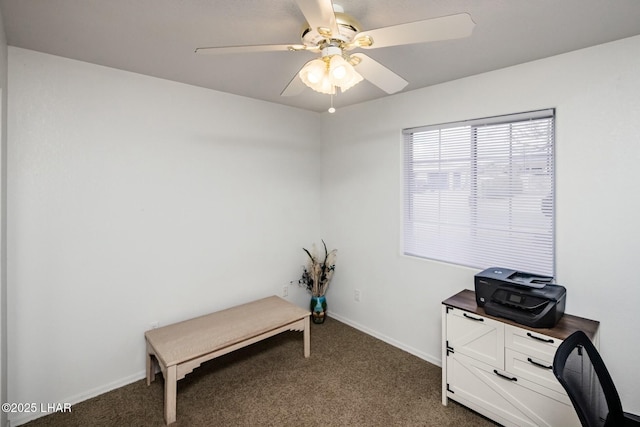 office area with baseboards, a ceiling fan, and dark colored carpet