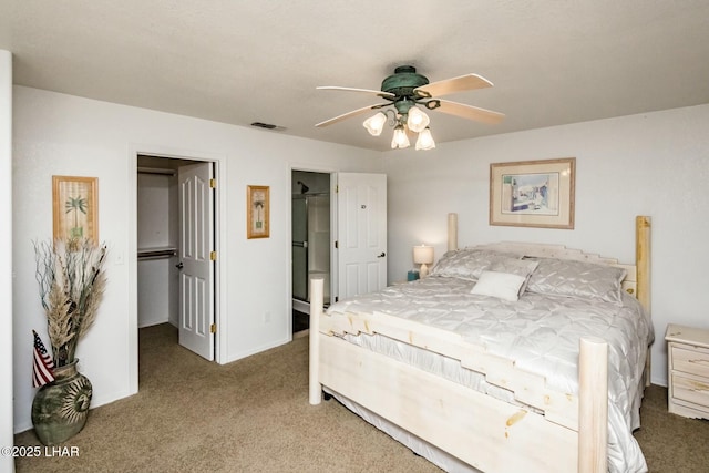 bedroom featuring a walk in closet, visible vents, a ceiling fan, a closet, and carpet flooring