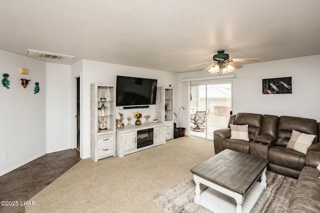 carpeted living area featuring visible vents and a ceiling fan