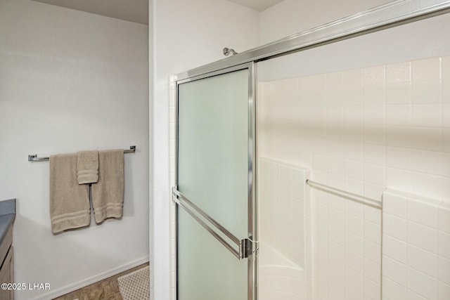 full bathroom featuring vanity, a shower stall, and baseboards