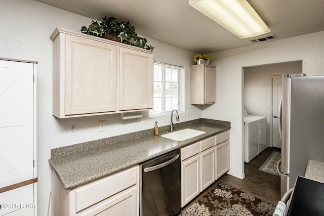 kitchen with a sink, stainless steel appliances, independent washer and dryer, and visible vents