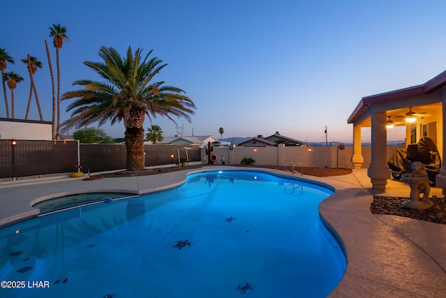 3712 Tahitian Dr, Lake Havasu City, AZ 86406 - pool at dusk featuring an in-ground hot tub, a fenced backyard, ceiling fan, and a patio