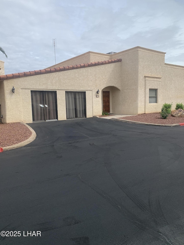 1008 Barcelona Unit 1, Lake Havasu City, AZ 86403 - mediterranean / spanish house featuring driveway, stucco siding, and an attached garage