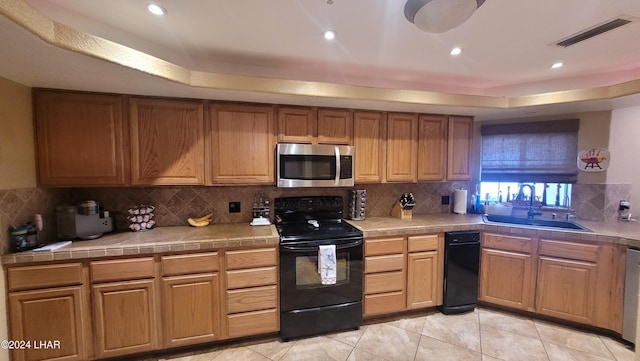 kitchen with sink, tile countertops, light tile patterned floors, black range with electric cooktop, and backsplash