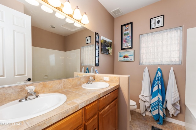 bathroom featuring visible vents, a sink, toilet, and double vanity