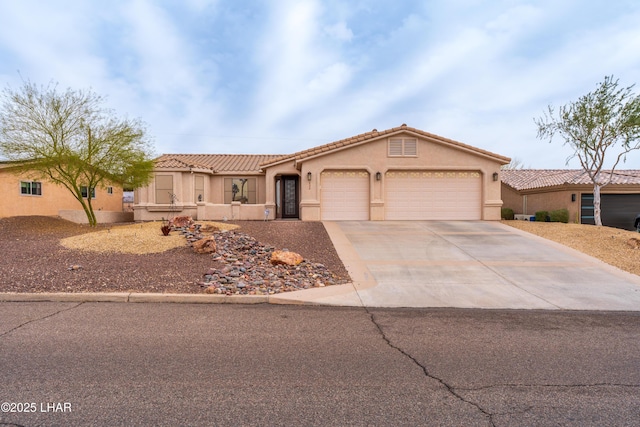 mediterranean / spanish house featuring an attached garage, driveway, a tile roof, and stucco siding