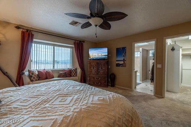 bedroom featuring ensuite bathroom, baseboards, visible vents, ceiling fan, and carpet floors