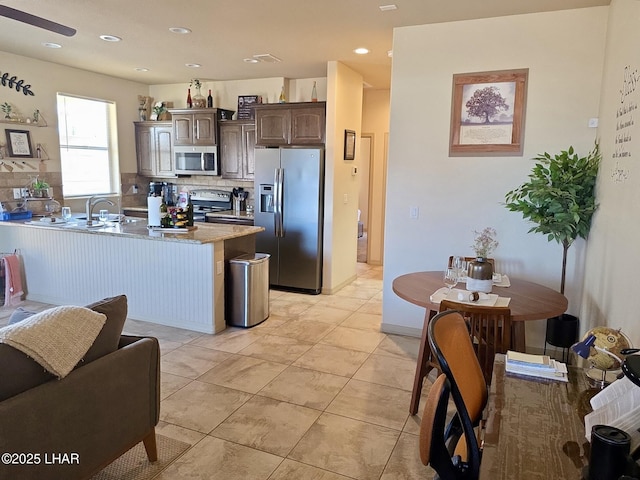2550 E Nez Perce Rd, Fort Mohave, AZ 86426 - kitchen featuring stainless steel appliances, dark brown cabinetry, decorative backsplash, a peninsula, and recessed lighting