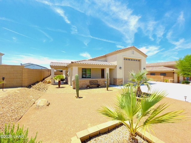 2550 E Nez Perce Rd, Fort Mohave, AZ 86426 - back of property with a garage, stone siding, stucco siding, driveway, and a tiled roof