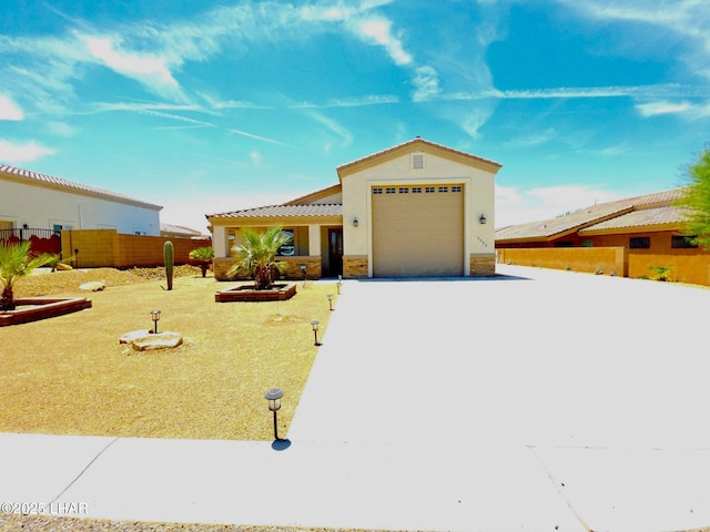 2550 E Nez Perce Rd, Fort Mohave, AZ 86426 - view of front facade with driveway, stucco siding, an attached garage, a tiled roof, and stone siding