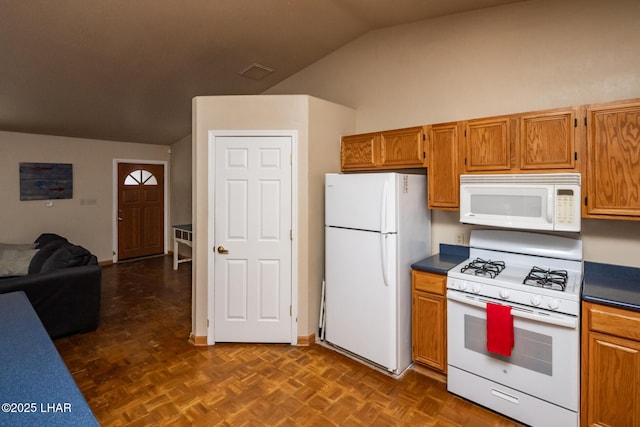 2613 Packet Ln, Lake Havasu City, AZ 86403 - kitchen with open floor plan, dark countertops, white appliances, brown cabinets, and lofted ceiling