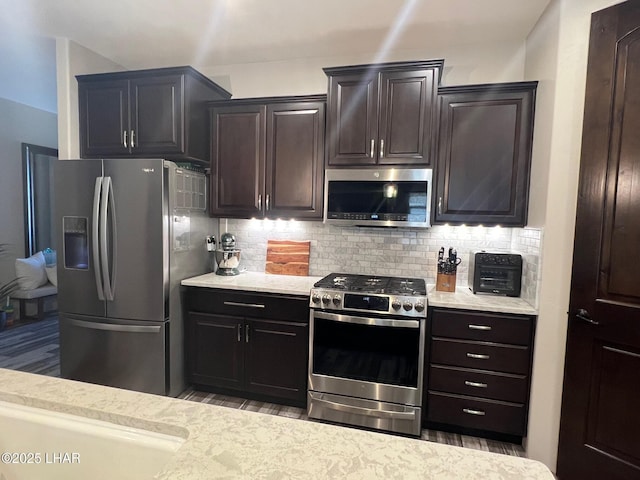 1737 E Alder Cir, Lake Havasu City, AZ 86404 - kitchen with stainless steel appliances, decorative backsplash, dark brown cabinets, and light stone counters