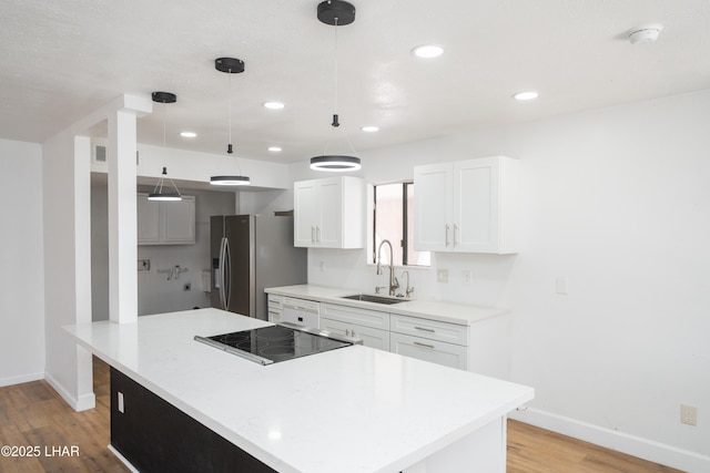 2340 Jamaica Blvd S, Lake Havasu City, AZ 86406 - kitchen featuring stainless steel fridge, baseboards, a sink, light wood-type flooring, and white cabinetry