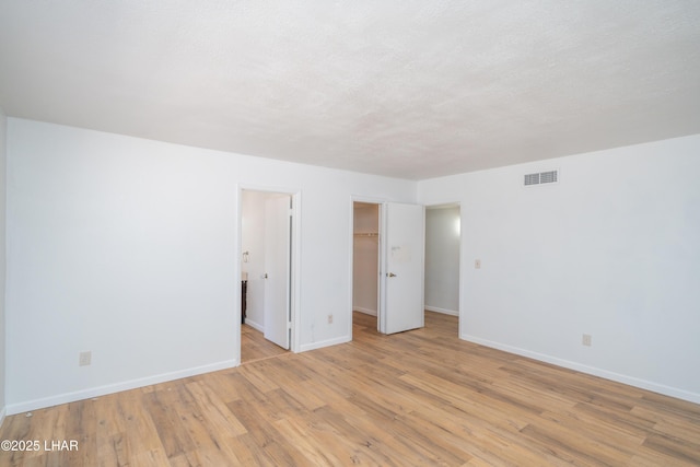 2340 Jamaica Blvd S, Lake Havasu City, AZ 86406 - unfurnished bedroom featuring baseboards, light wood finished floors, a walk in closet, and a closet