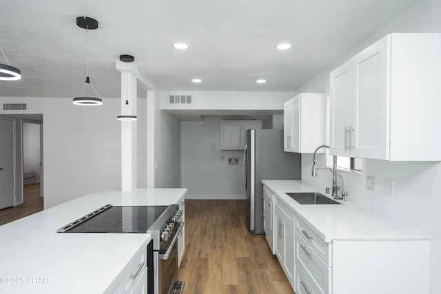 2340 Jamaica Blvd S, Lake Havasu City, AZ 86406 - kitchen with a sink, stainless steel appliances, wood finished floors, white cabinets, and light countertops