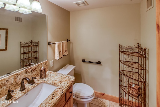half bath with visible vents, toilet, and vanity