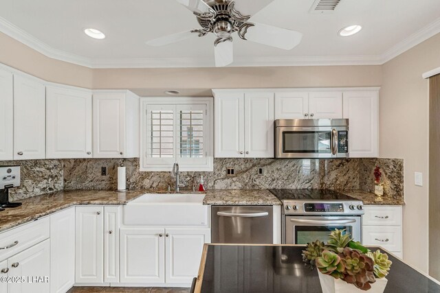8874 Papago Loop, Parker, AZ 85344 - kitchen featuring appliances with stainless steel finishes, ceiling fan, decorative backsplash, white cabinets, and crown molding