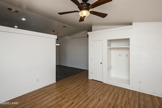 unfurnished room featuring ceiling fan, visible vents, lofted ceiling, and wood finished floors