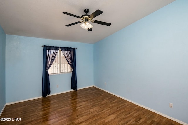 spare room with baseboards, wood finished floors, and a ceiling fan