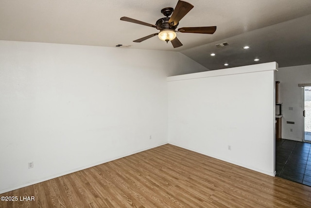 empty room featuring visible vents, a ceiling fan, and wood finished floors