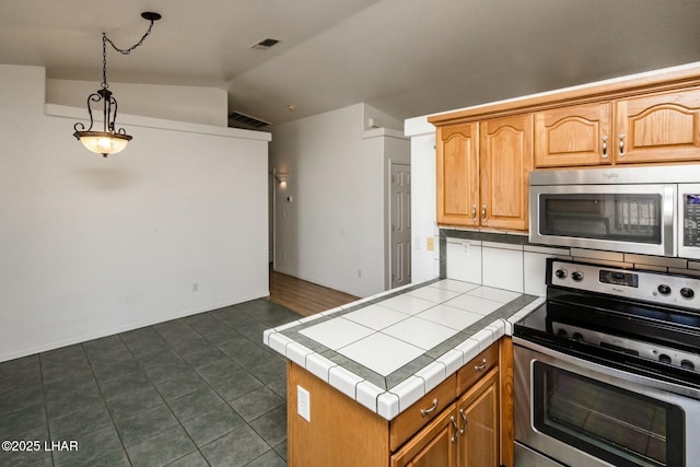 kitchen featuring vaulted ceiling, visible vents, stainless steel appliances, and tile counters