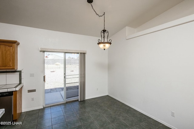 unfurnished dining area with baseboards, lofted ceiling, and dark tile patterned floors