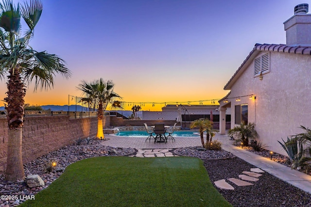 yard at dusk featuring a patio area