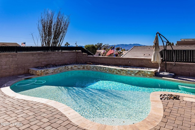 view of swimming pool with a patio and a mountain view