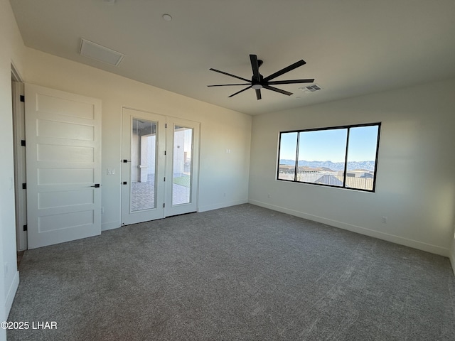 unfurnished room with a mountain view, carpet floors, and ceiling fan