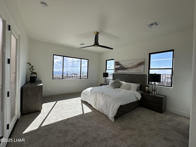 bedroom featuring multiple windows, ceiling fan, and dark colored carpet