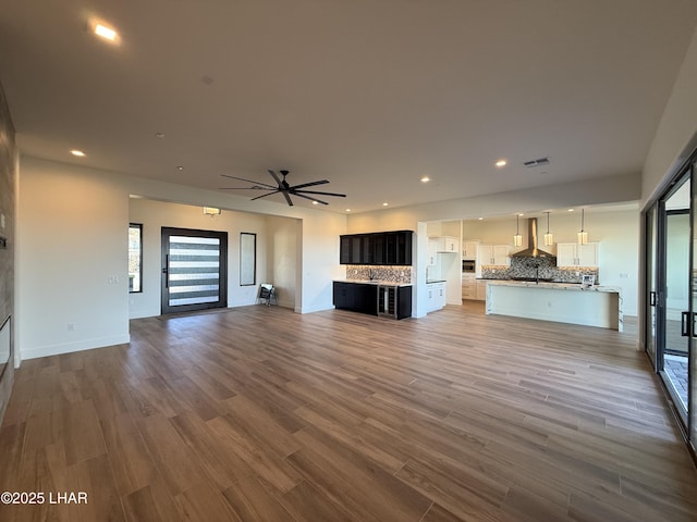 unfurnished living room with hardwood / wood-style flooring and ceiling fan