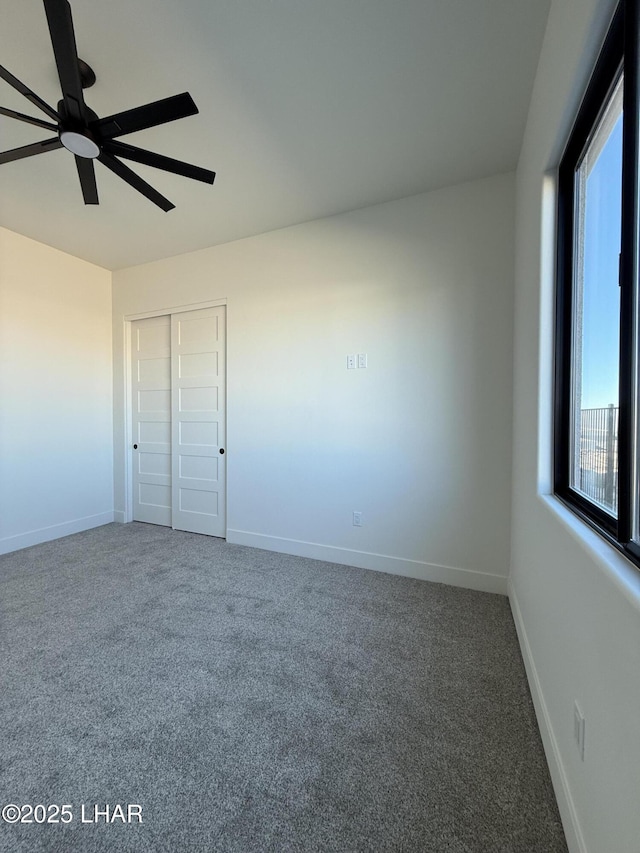 unfurnished bedroom featuring ceiling fan, a closet, and carpet